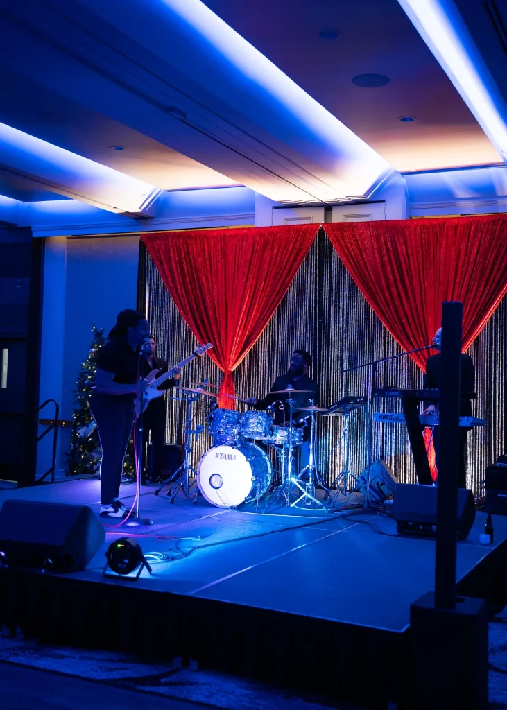 SuperSonic Heart Band performing on stage at the Picture Perfect Cleaning Christmas Party at Carriage House Inn in Calgary.